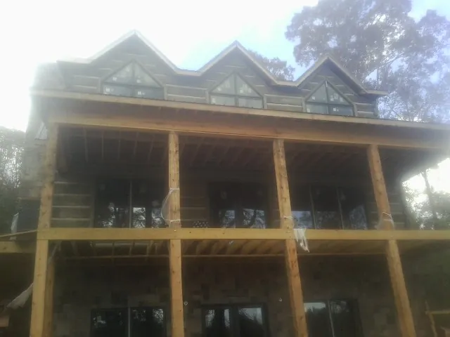 Dormers and porch framing on a large log home under construction — Roof Coating work by our crew in Jonas Ridge