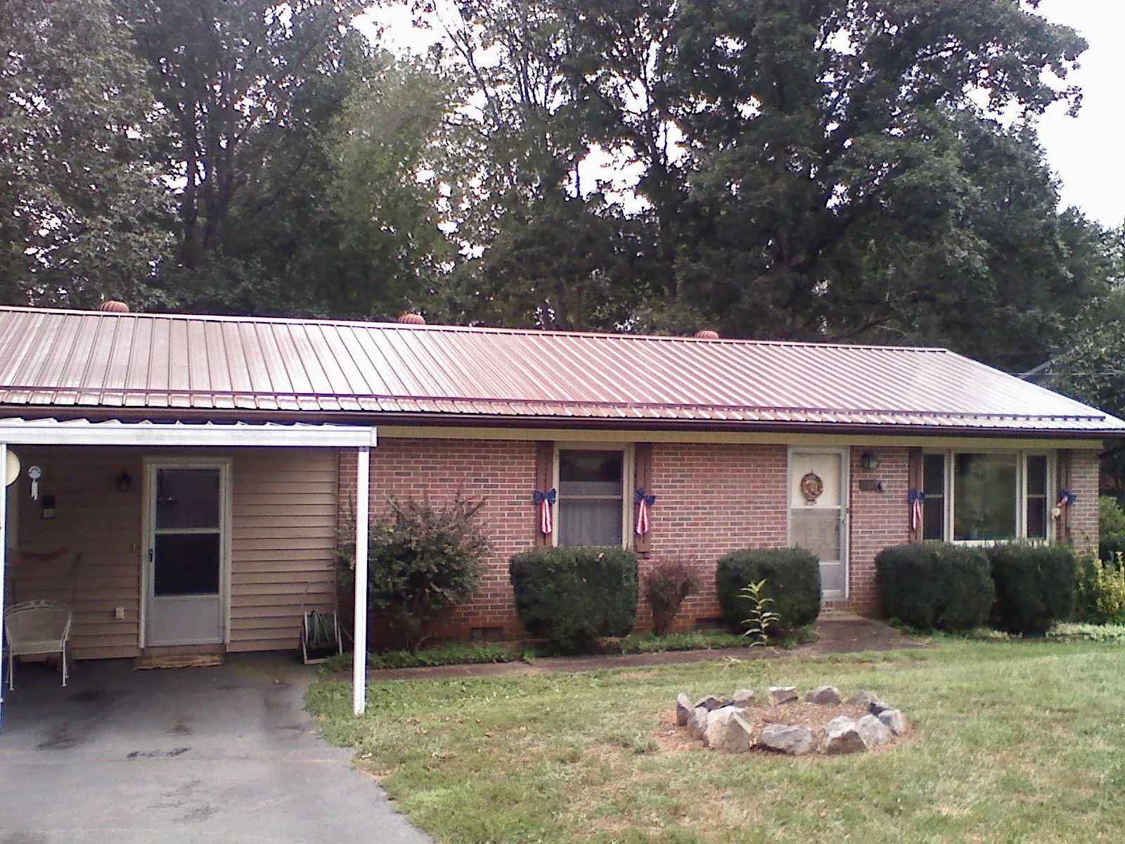 Bronze metal roof and carport on a brick ranch home — Roof Repair work by our crew in Jonas Ridge